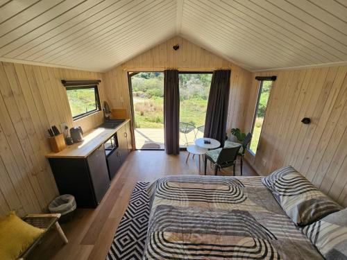 ein Schlafzimmer mit einem Bett in einem Zimmer mit Holzwänden in der Unterkunft Fish Eagle River Camp in Vosburg
