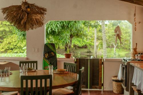 a dining room with a table and a large window at Barrinha dos Ventos Barrinha de Baixo Ceara Quartos Casas Kitesurf in Acaraú