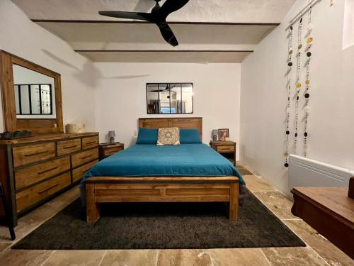 une chambre avec un lit et un ventilateur de plafond dans l'établissement L'Ecrin de Mérindol, à Mérindol
