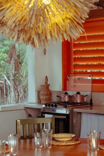 a kitchen with a stove and a table with chairs at Barrinha dos Ventos Barrinha de Baixo Ceara Quartos Casas Kitesurf in Acaraú