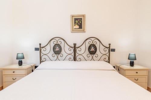 Un dormitorio con una cama blanca con dos mesitas de noche. en Villa Aurelio, en Capilungo