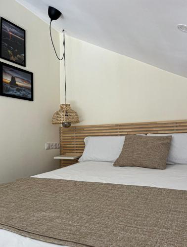 a bedroom with a large bed with a wooden headboard at Apartamento Costa Quebrada in Liencres