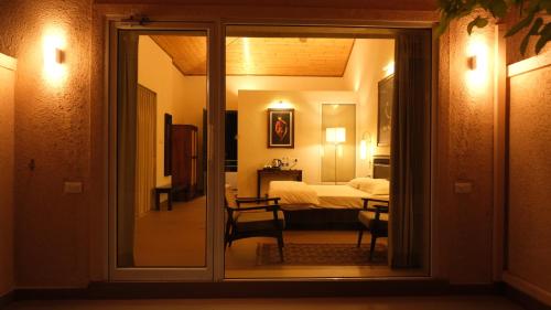 a view of a bedroom through a sliding glass door at The Riverstone Agro Farm in Vajapūr