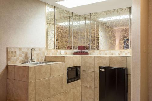 a kitchen with a sink and a mirror at SureStay Hotel by Best Western SeaTac Airport North in SeaTac