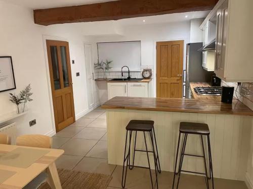 a kitchen with a counter and two bar stools at Carrick Retreat - Free off street parking in Carrickfergus