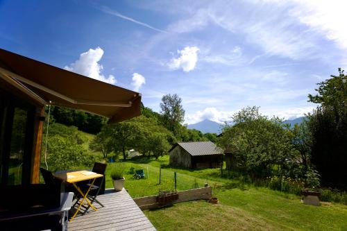 eine Holzterrasse mit Blick auf ein Feld in der Unterkunft La Tiny House des Montagnes in Verrens-Arvey