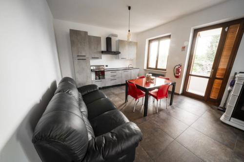 a living room with a leather couch and a table at Tenuta Oasi del cavallo in Sommacampagna