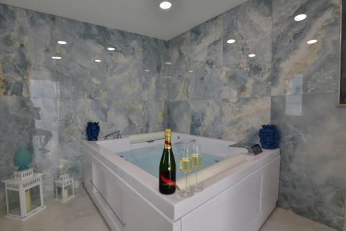 a bathroom with a bath tub with a bottle of champagne at Appartamento Ortigia Vicolo Lettighieri 22 in Siracusa