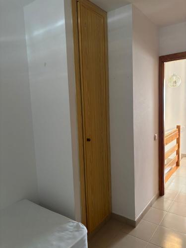 a room with a bed and a wooden door at Casa Estrella Fuerteventura in Costa de Antigua