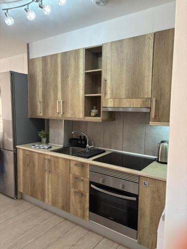 a kitchen with wooden cabinets and a sink at Casa Estrella Fuerteventura in Costa de Antigua