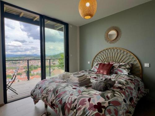 une chambre avec un lit et une grande fenêtre dans l'établissement TheView, piscine et sauna, au Puy-en-Velay