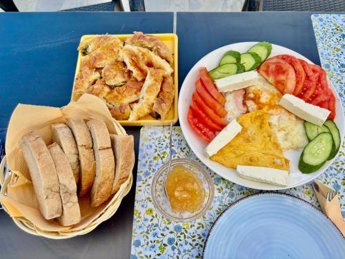 Una mesa cubierta con dos platos de comida con sándwiches y verduras. en Blen Grand, en Berat