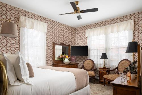 a bedroom with a bed and a ceiling fan at The Mason Cottage Downtown in Cape May