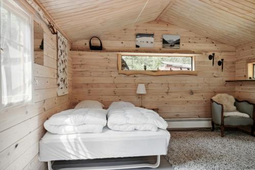 a bed in the corner of a room with wooden walls at Close To Nature In Home With Own Lake in Jægerspris