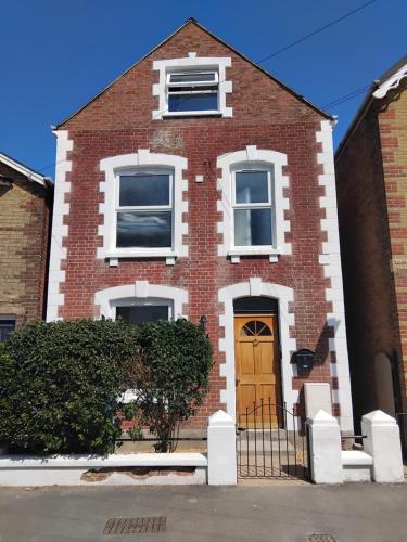 a red brick house with a yellow door at Heart of Cowes - 10 Guests, 200m to Town, Sea View in Cowes