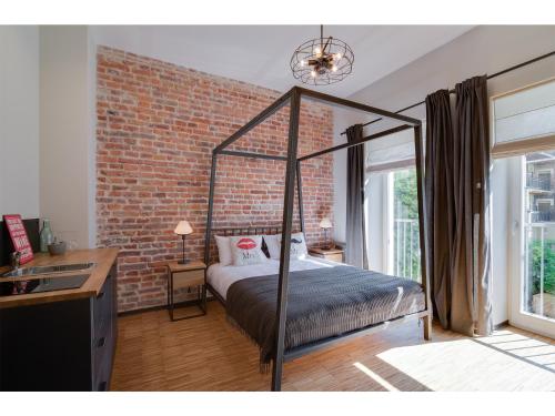 a bed sitting in a bedroom next to a window at Well Well Aparthotel in Kraków