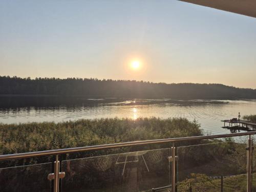 a view of a lake with the sun in the sky at Apartament nr 9 Mazurskie Klimaty in Tomaszkowo