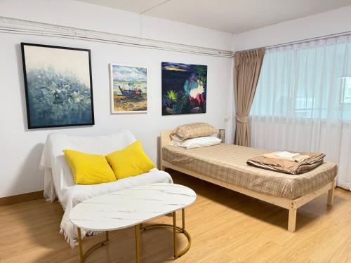 a room with two beds and a couch and paintings at Chummy House Khaosan 10-Min, Peace Haven in Bangkok
