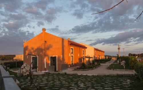 an orange building with a courtyard in front of it at Palascìa Wellness Relais in Otranto