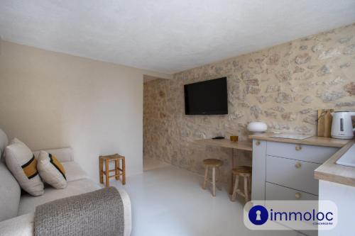 Cette chambre comprend un lit et une télévision murale. dans l'établissement Studio in Villefranche, à Villefranche-sur-Mer