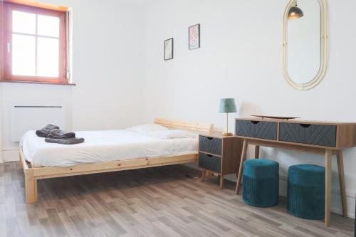 une chambre avec un lit, un bureau et un miroir dans l'établissement Le Vintage, Mulhouse ville, à Mulhouse