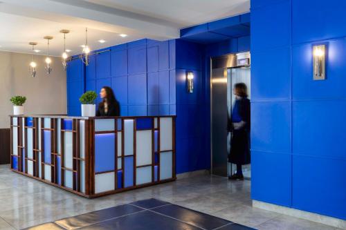 two people standing in a room with blue walls at Jardins Eiffel in Paris