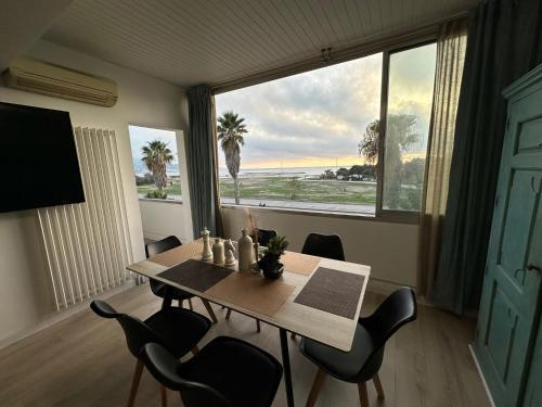 une salle à manger avec une table et une grande fenêtre dans l'établissement Appart T3 vue mer en face des JO, à Marseille