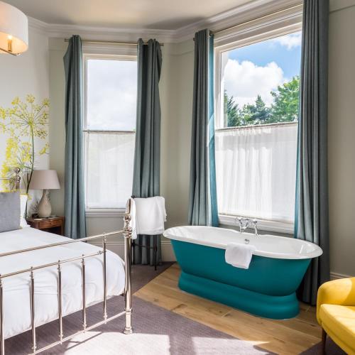 a bedroom with a blue tub in front of a window at The High Field Town House in Birmingham