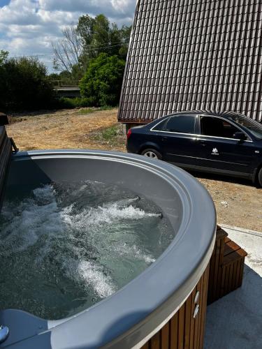 a jacuzzi tub with a car parked in a yard at Casuțele de la răscruce in Uric