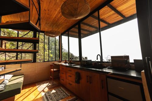 a kitchen with windows and a counter with a sink at Luxury Casa Árbol Amazing View in Jaibalito