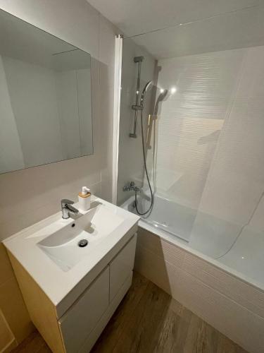 une salle de bain blanche avec un lavabo et une douche dans l'établissement Appart T3 vue mer en face des JO, à Marseille
