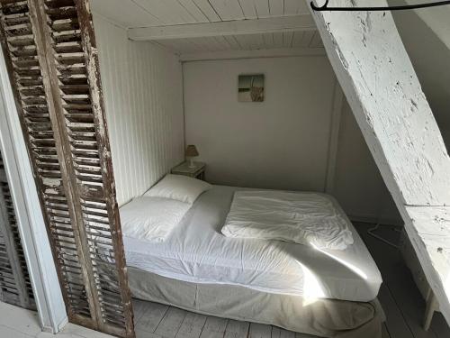 une petite chambre avec un lit dans une pièce dans l'établissement Cabine du Capitaine 5, à Fécamp