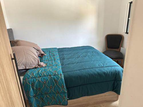 - une chambre avec un lit doté d'une couette bleue et d'une chaise dans l'établissement Maison des Sables - A côté de la Plage dans le Golfe de Saint-Tropez, à Grimaud
