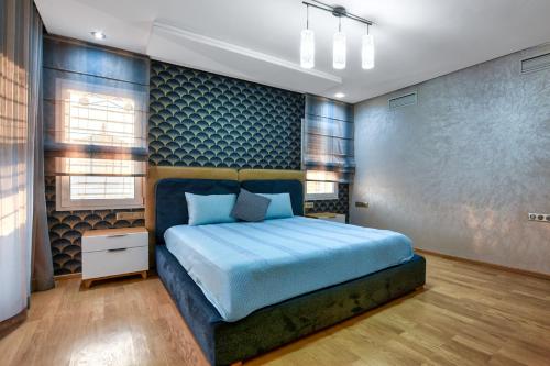a bedroom with a bed and a blue wall at La Villa Del Mar in Agadir
