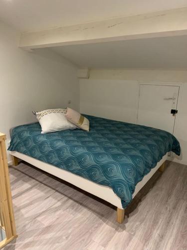 - un lit dans une chambre avec une couette verte dans l'établissement Appart T3 vue mer en face des JO, à Marseille