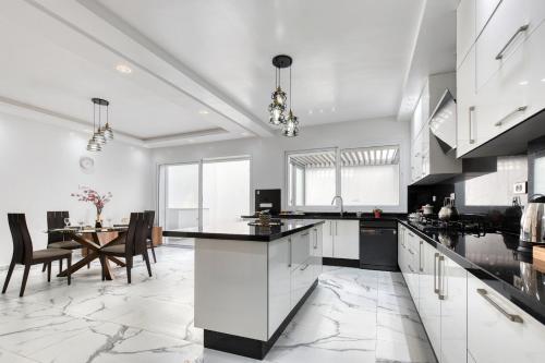 a kitchen with white cabinets and a dining room with a table at La Villa Del Mar in Agadir