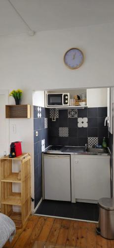 - une petite cuisine avec du carrelage noir et blanc dans l'établissement Studio Arcole Metro Botanical Garden, à Toulouse