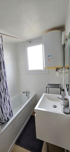 une salle de bain blanche avec une baignoire et un lavabo dans l'établissement Studio Arcole Metro Botanical Garden, à Toulouse