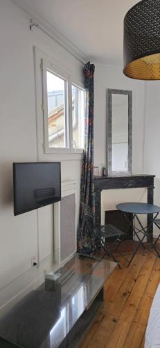 un salon avec une télévision à écran plat et une table dans l'établissement Studio Arcole Metro Botanical Garden, à Toulouse