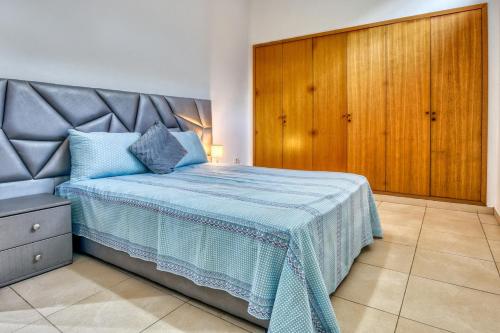a bedroom with a bed and a wooden cabinet at La Villa Del Mar in Agadir