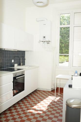 - une cuisine avec des placards blancs et un sol en damier dans l'établissement Flat La Croisette Cannes La Croix d'Or, à Cannes