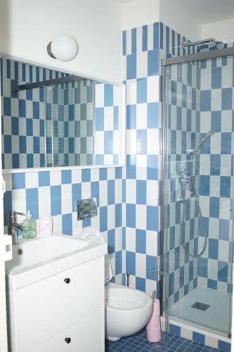 La salle de bains est pourvue d'un mur en damier bleu et blanc. dans l'établissement Flat La Croisette Cannes La Croix d'Or, à Cannes