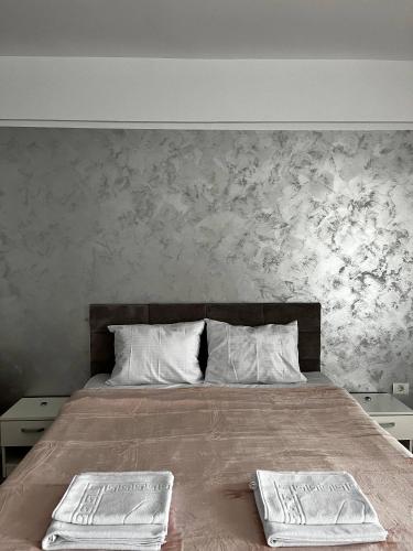 a bedroom with a bed with two towels on it at Mamaia Sea Vibe in Mamaia Sat/Năvodari
