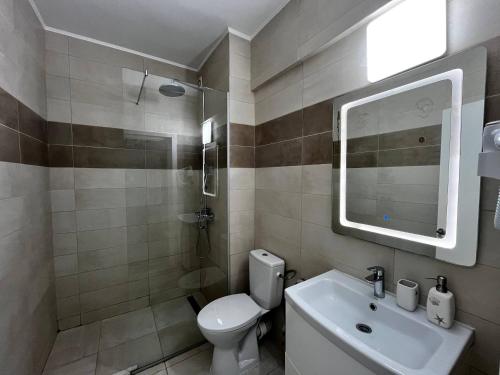 a bathroom with a toilet and a sink and a mirror at Mamaia Sea Vibe in Mamaia Sat/Năvodari