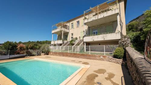 une maison avec piscine devant un immeuble dans l'établissement Marelle, à Vals-les-Bains