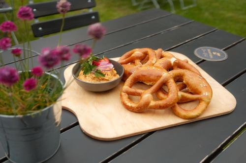 a wooden cutting board with onion rings on a table at QUARTIER 5 Hotel & Restaurant, Sächsische Schweiz in Kurort Gohrisch