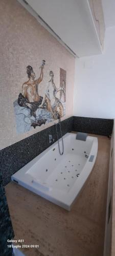 a bathroom with a bath tub with a painting on the wall at Casa di vacanza La Perla in Capri
