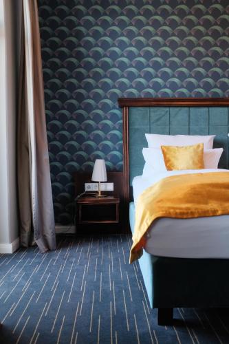 a bedroom with a bed and a blue wall at QUARTIER 5 Hotel & Restaurant, Sächsische Schweiz in Kurort Gohrisch