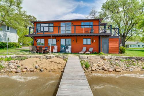 an orange house with a dock in the water at Steps to Powers Lake Wisconsin Family Home in Burlington