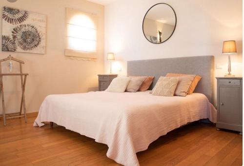 une chambre avec un grand lit avec un grand miroir dans l'établissement Villa les Oliviers, à Aubignan